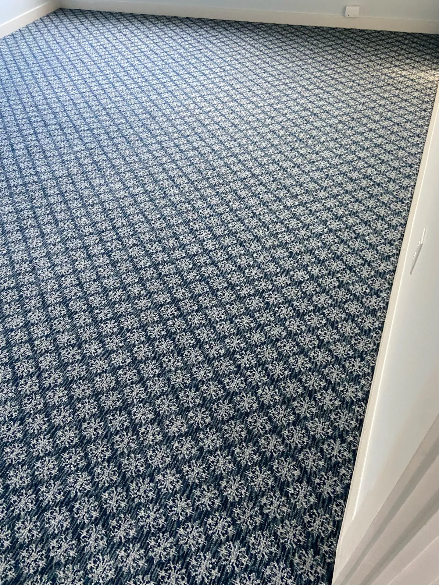 Blue floral patterned carpet installation