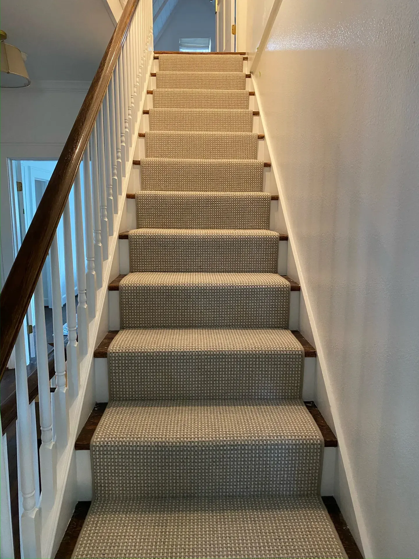 Woven checkered stair runner over stained wood treads