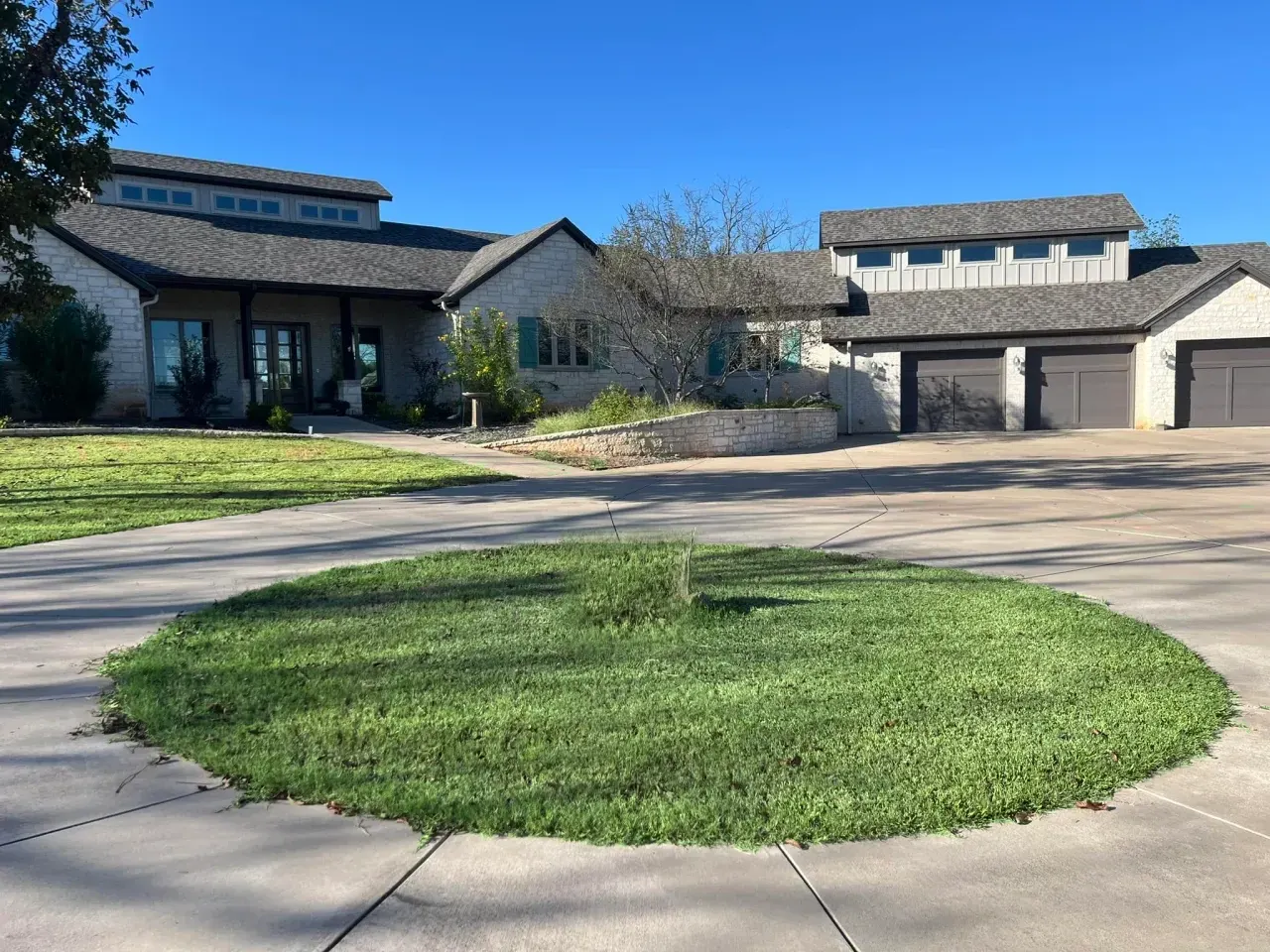 Stone custom home with a three-car garage and circular drive