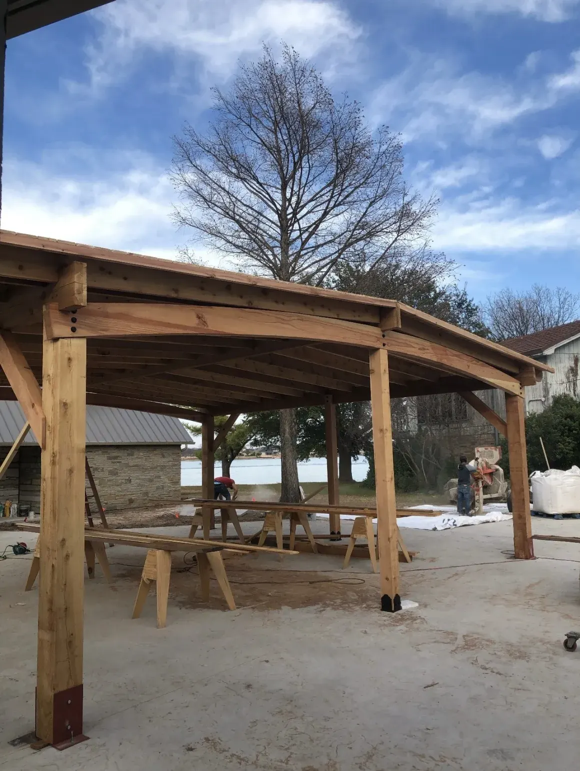 Timber-frame pergola under construction on the lakefront