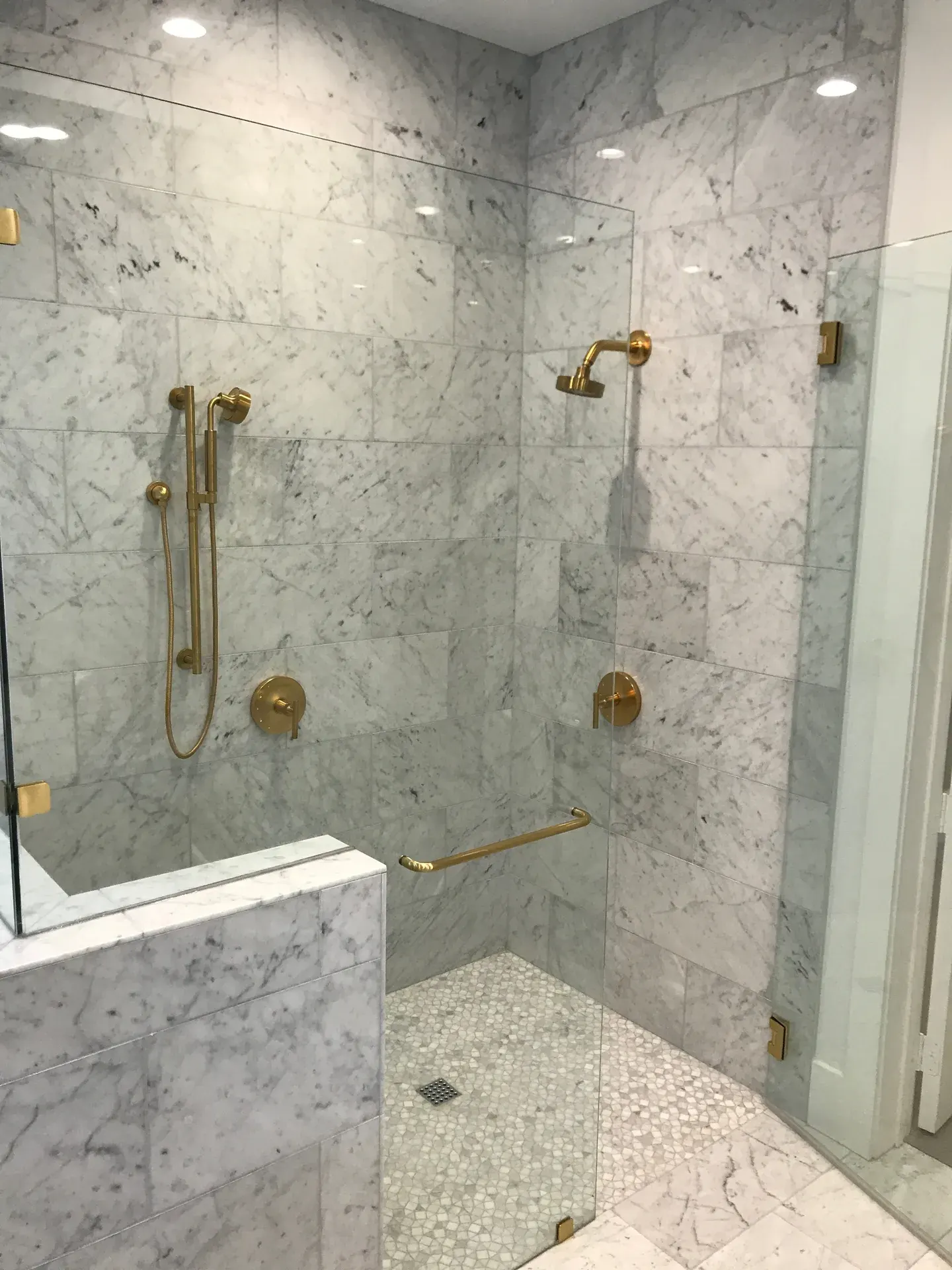 Carrara marble double shower with brushed-gold fixtures