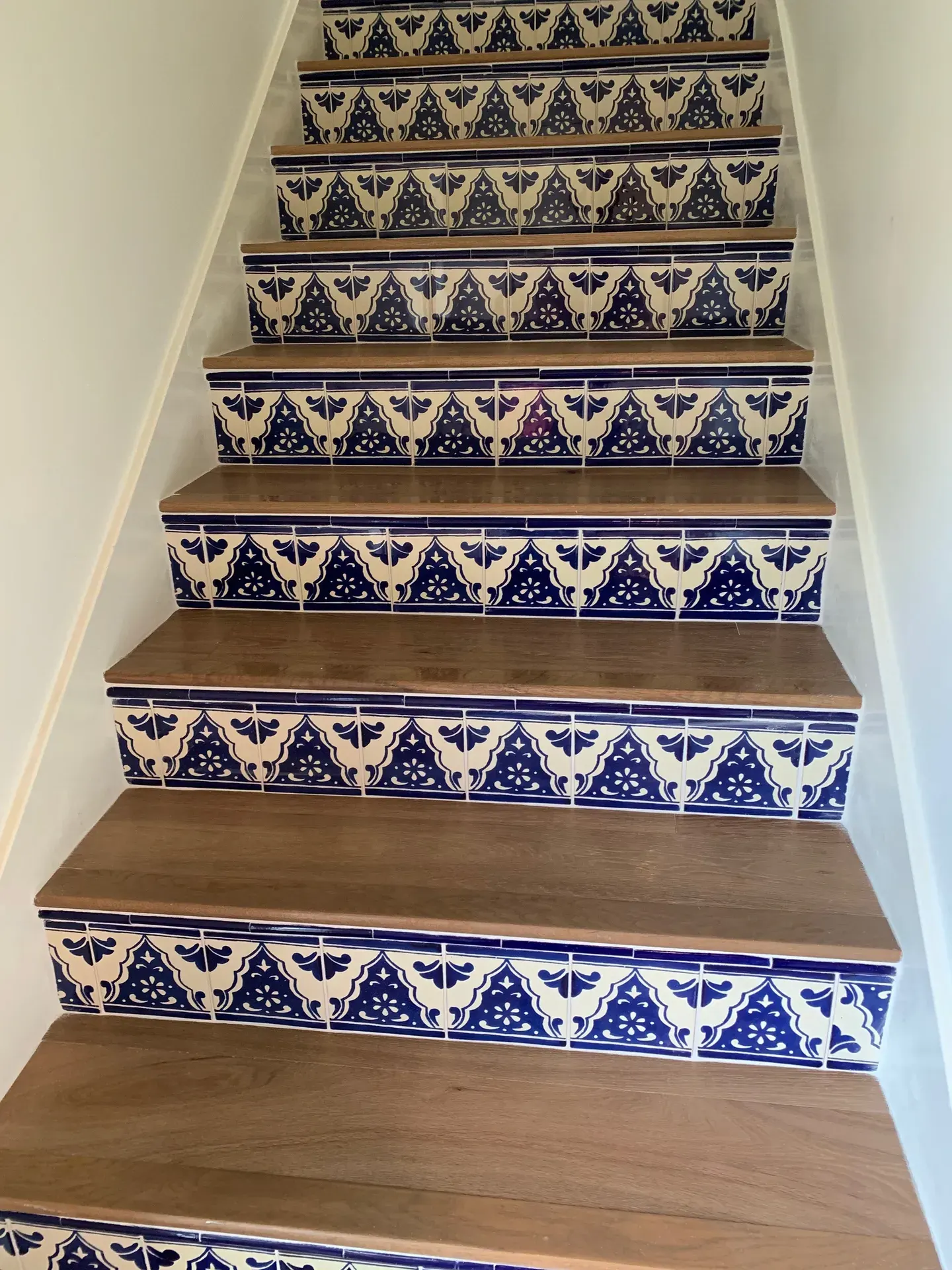 Staircase with hand-painted blue Talavera tile risers and wood treads