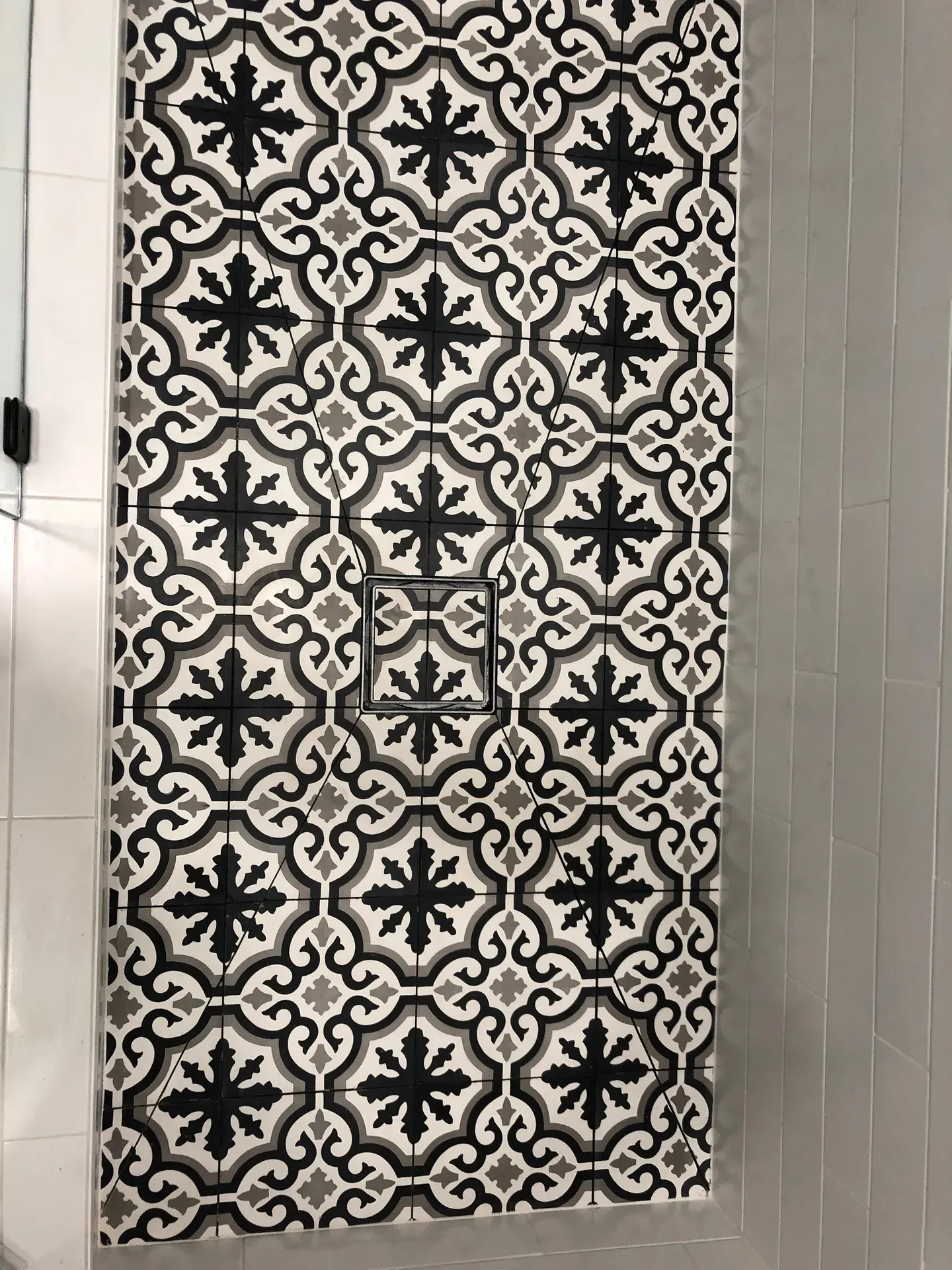 Patterned black-and-white cement tile shower floor